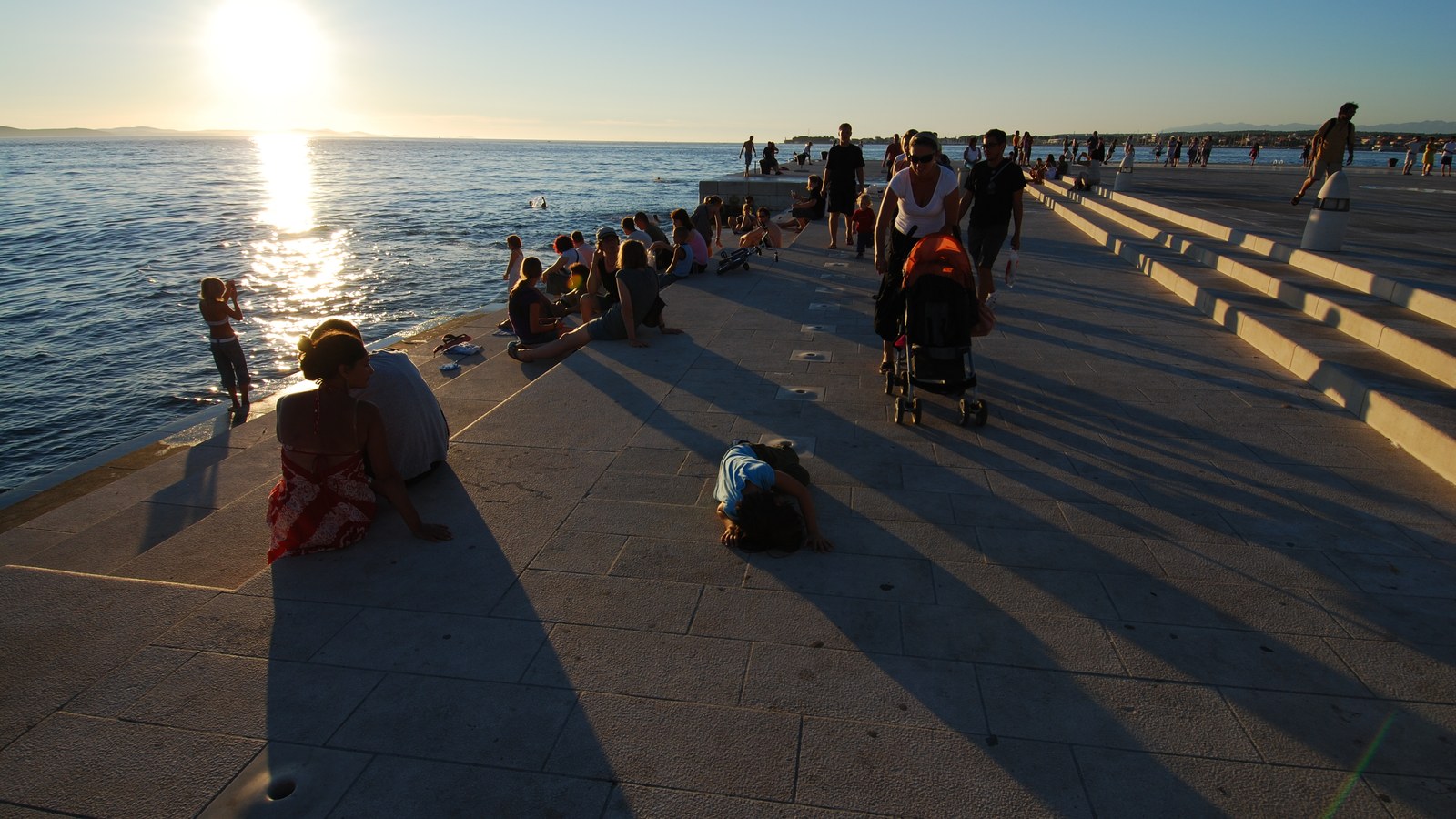 Visitors listening at sunset on the Sea Organ steps in Zadar, Croatia