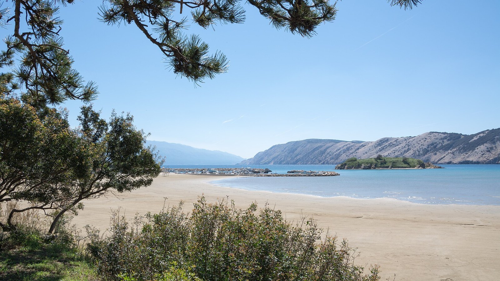Rajska Plaza, the wide sandy beach at Lopar on Rab Island, Croatia, with shallow turquoise water